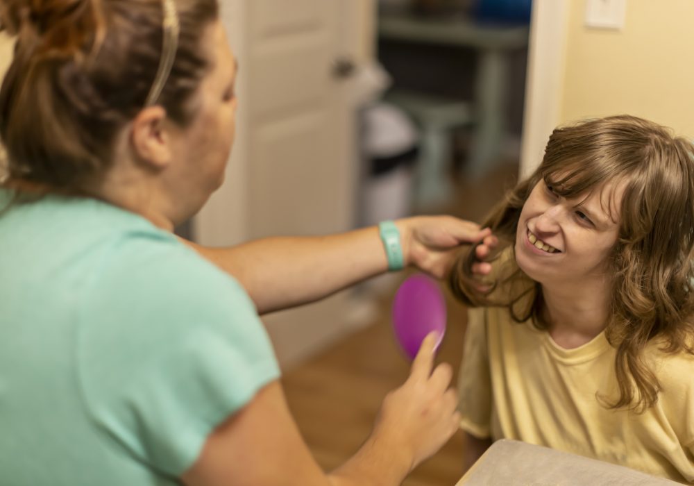 Intellectually disabled young woman needs assistance with all forms of daily living including having her hair brushed every day.